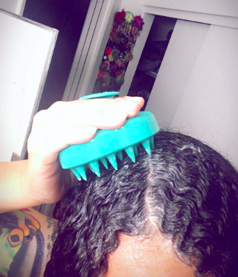 reviewer using the shampoo brush on their scalp