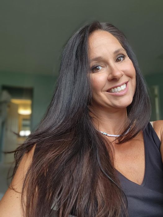 Person smiling with sleek, straight hair