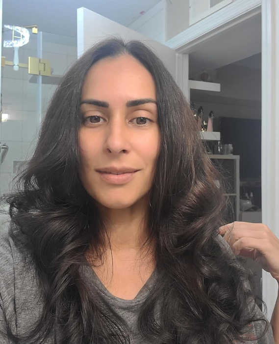 A reviewer showing their hair after using the thermal brush to create a smooth blowout