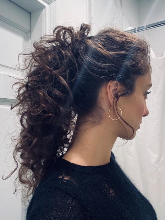 A reviewer showcasing their high curly ponytail secured with the banana clip