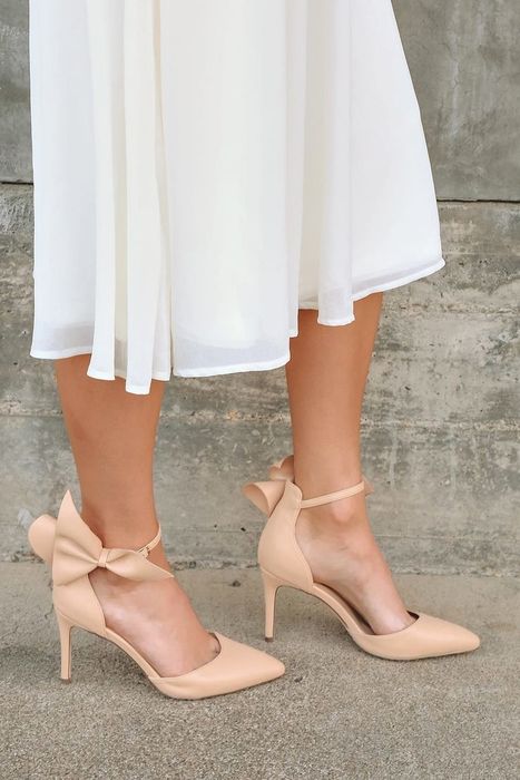 A model sporting a white bottom and beige shoes