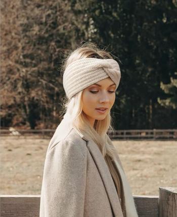 A model wearing the beige twist-knit headband.