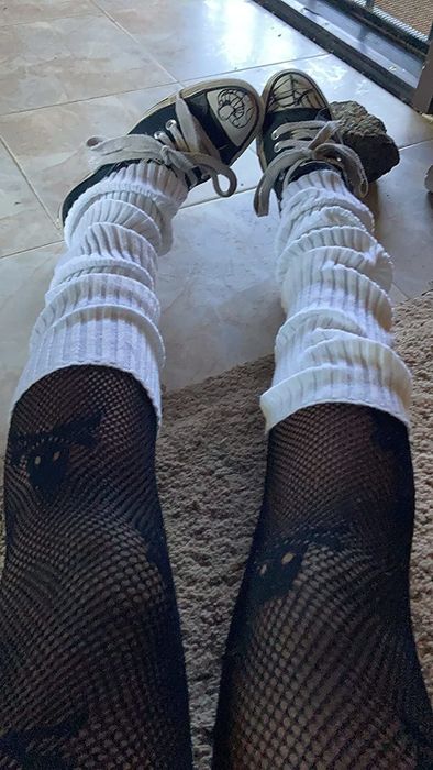 A reviewer shows off the leg warmers worn with tights and sneakers.