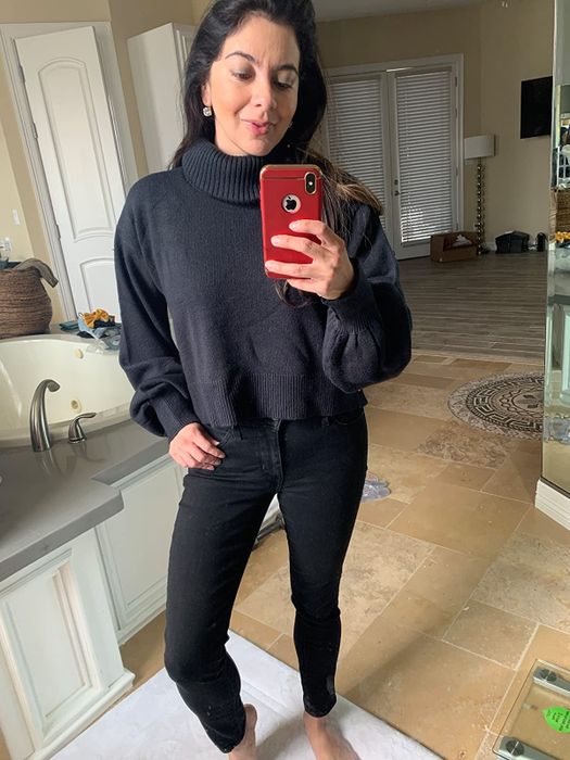 A reviewer sporting the black turtleneck paired with black pants.