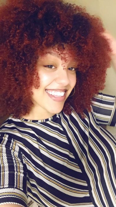 A reviewer showing off defined coily hair