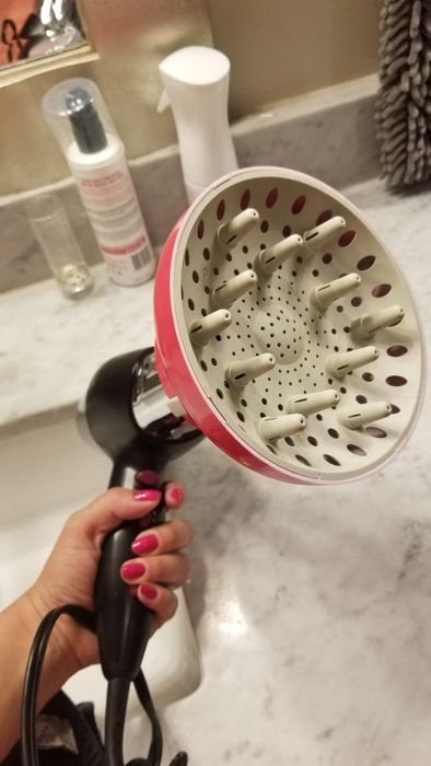 Another reviewer's pink and white diffuser attached to a blow dryer