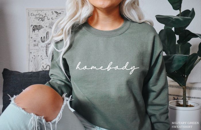 A model showcasing the green sweatshirt with the words on it.