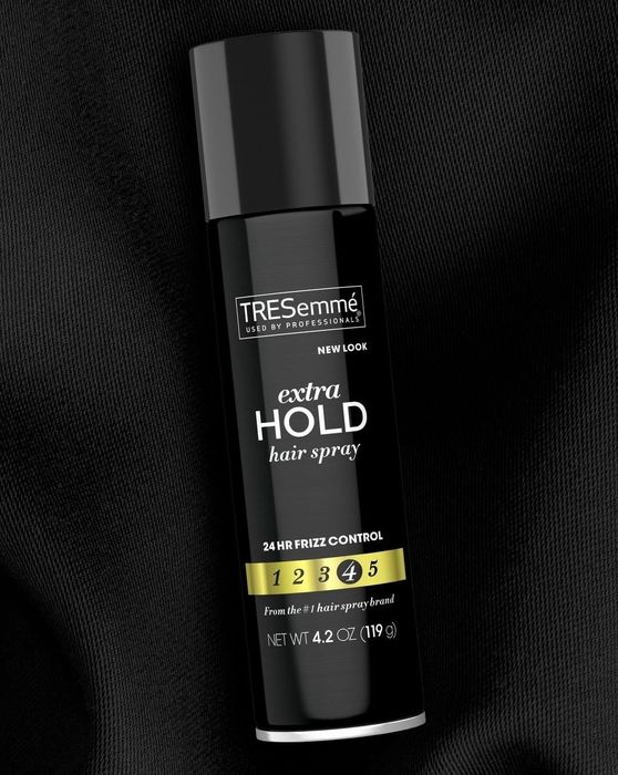 The bottle of hairspray set against a black background