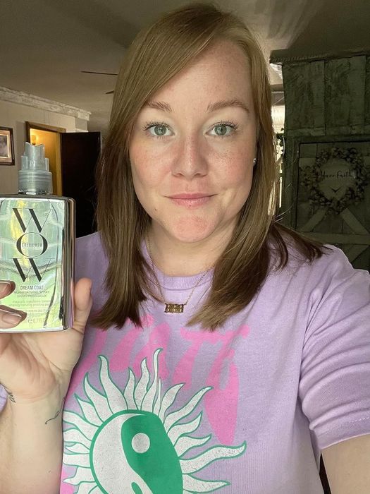 Reviewer holding the spray, showing it applied in their hair