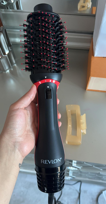 Another reviewer holding the hair dryer brush