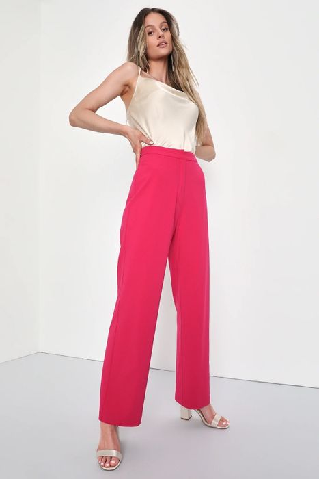A model dressed in a white camisole, pink trousers, and champagne-hued shoes.