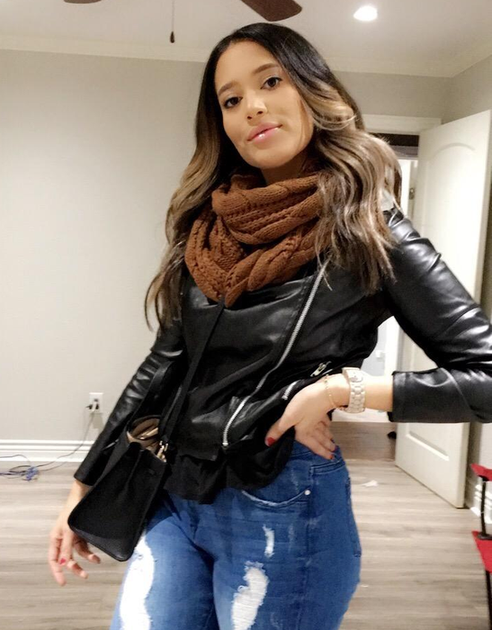 A reviewer sporting a brown scarf paired with a leather jacket