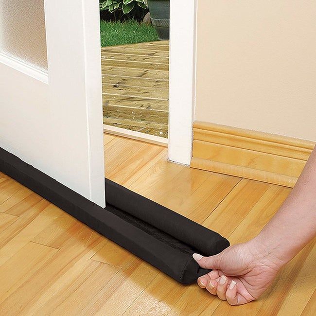 Model placing the draft guard under a door to block drafts