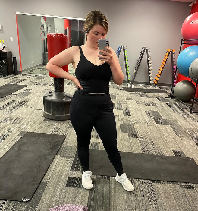 Reviewer snapping a mirror selfie at the gym while wearing the black joggers