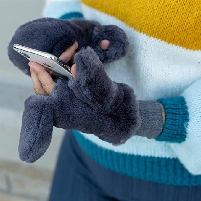 A model wears a pair of grey mittens that are both stylish and functional.