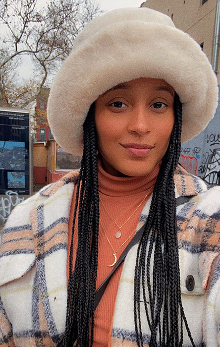 a reviewer wearing the chic white faux fur hat