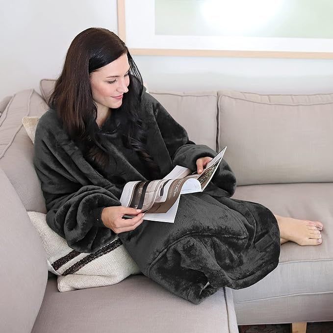 Model lounging on the couch wearing the black blanket hoodie