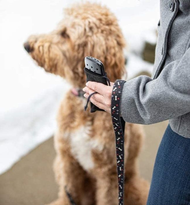 A model holds the sleek black hand warmer in their hand.