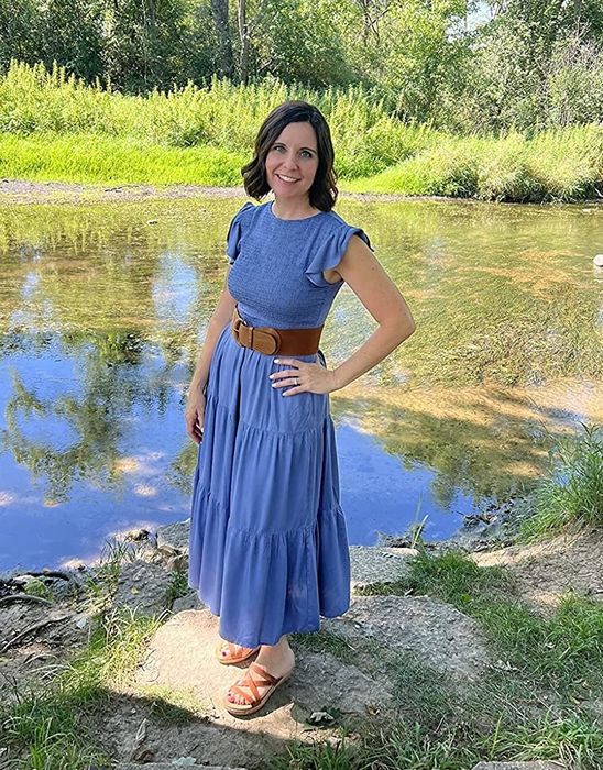 Reviewer wearing the dress in blue, styled with leather sandals.