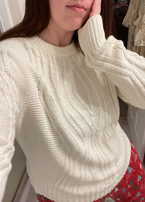 close-up of reviewer wearing the white crewneck sweater