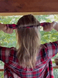 A gif demonstrating someone using the bun maker to style their hair into a bun