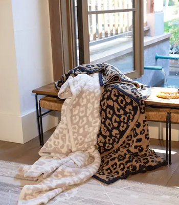 Two leopard print blankets draped over a bench, ready for cozy moments.