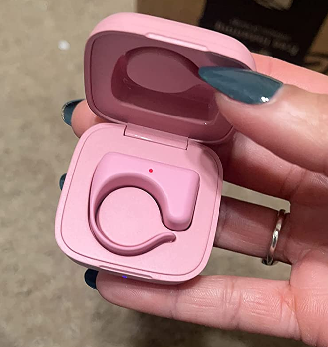 Reviewer showcasing the pink remote held in its charging case