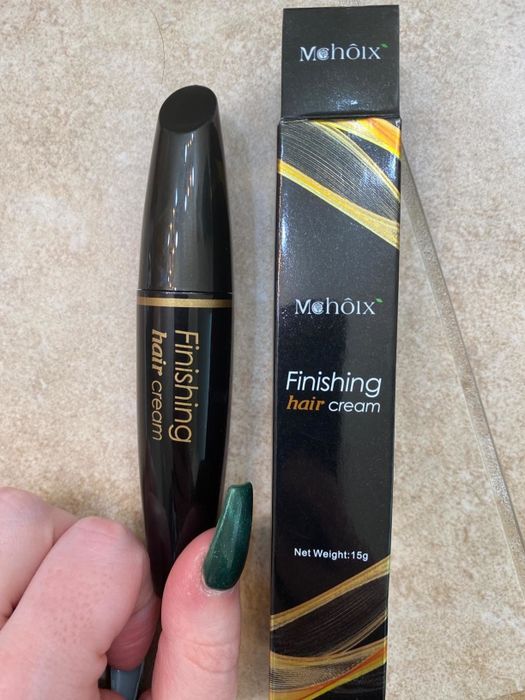 Reviewer holding the finishing cream stick