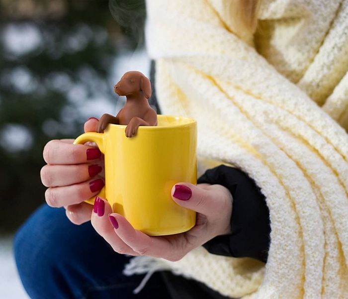a model showing off the infuser in a yellow mug