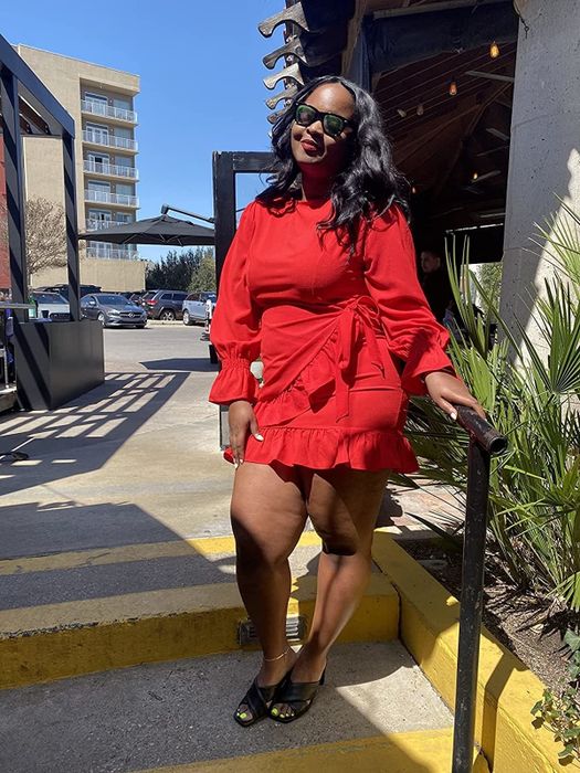 A reviewer shows off the red dress paired with black slides.