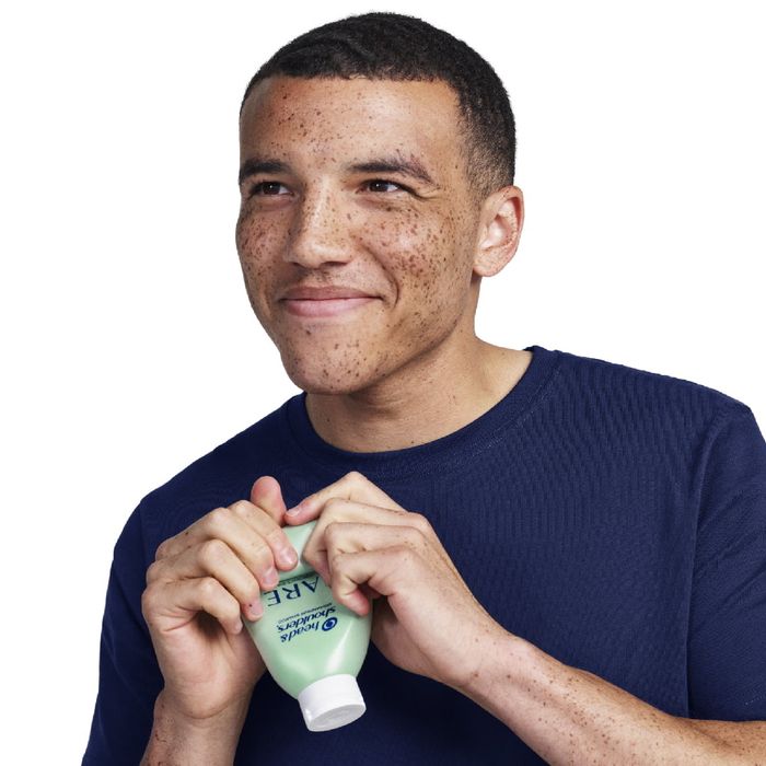 A model holding a bottle of shampoo