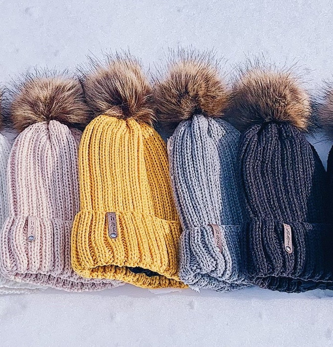 four beanies in different colors lined up together