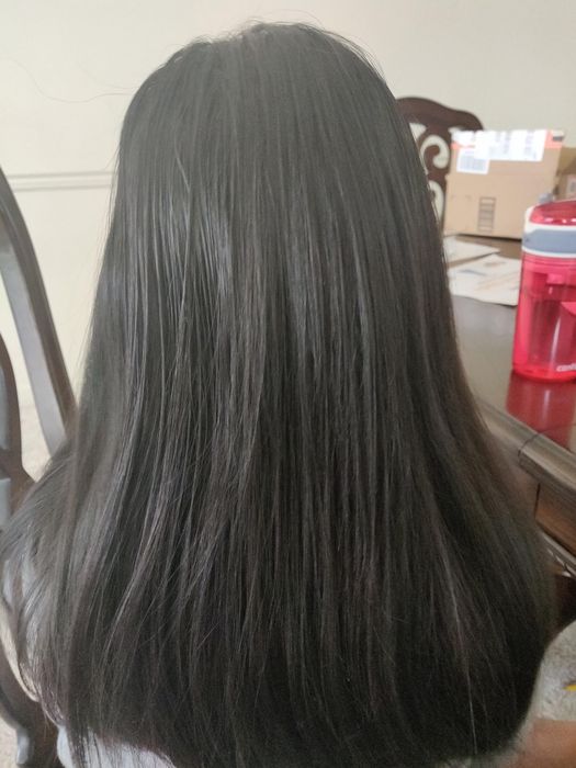 A reviewer is shown from behind, showcasing her long, straight hair in an indoor setting.