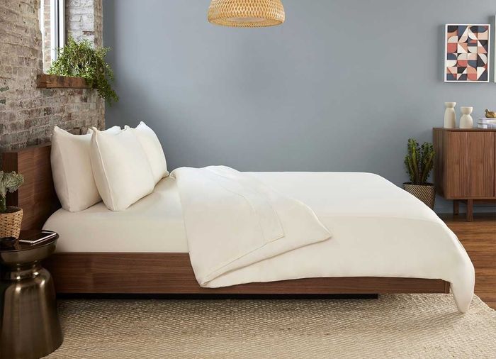 a bed dressed in the beige sheet set