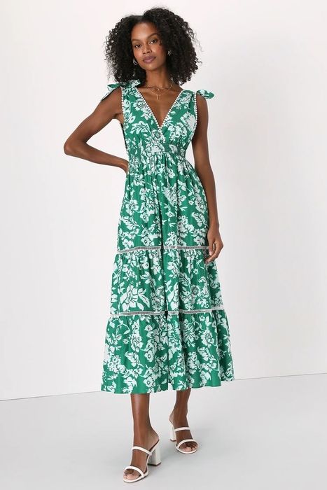A model in a green and white dress with white sandals.