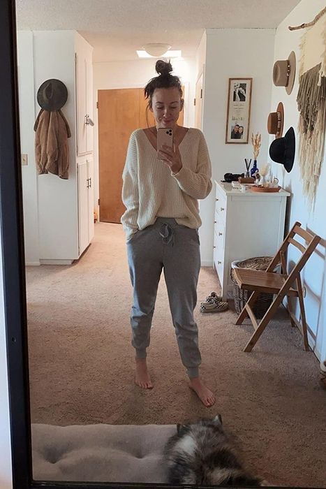 A reviewer models the light gray sweatpants