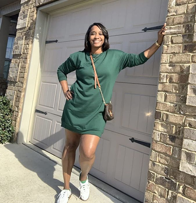 A reviewer wearing the green version of the dress.
