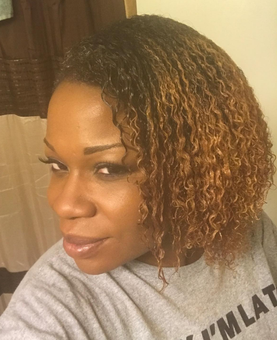 A reviewer displays their beautifully defined curly hair after using the brush, highlighting its effectiveness.