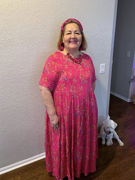 Customer wearing the dress in hot pink with floral accents.