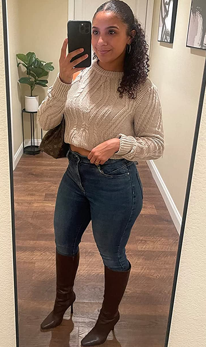 reviewer wearing a beige crewneck sweater, cropped and paired with jeans and boots