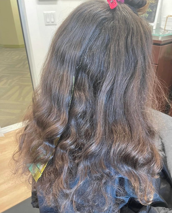 A reviewer with dry, slightly wavy hair before using the product.