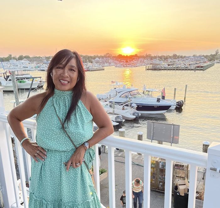 A reviewer wearing the dress in blue with white polka dots