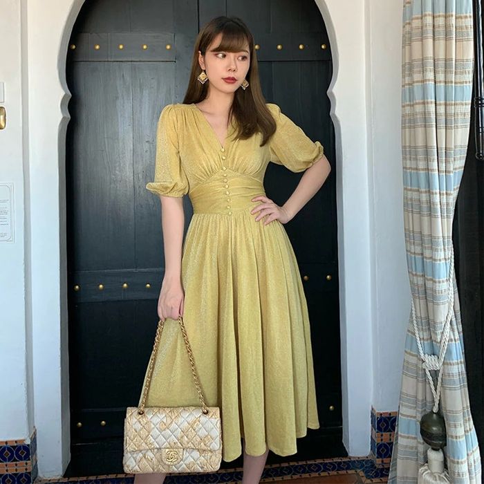 A model showcasing the dress in a cheerful yellow shade.