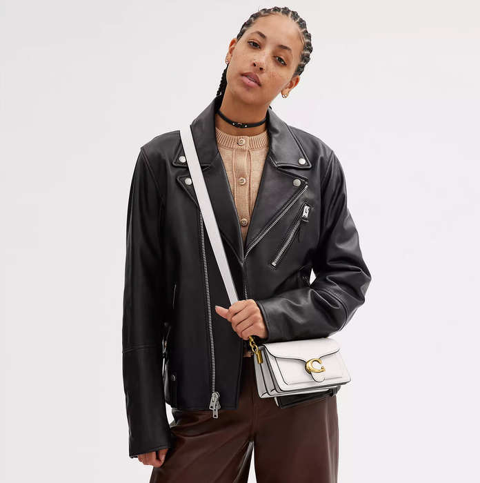another model wearing the white version as a crossbody bag