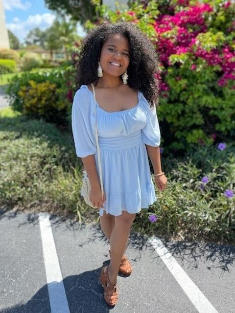 A reviewer wearing the light blue dress