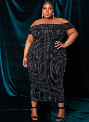 A model styling the dress with black heels.