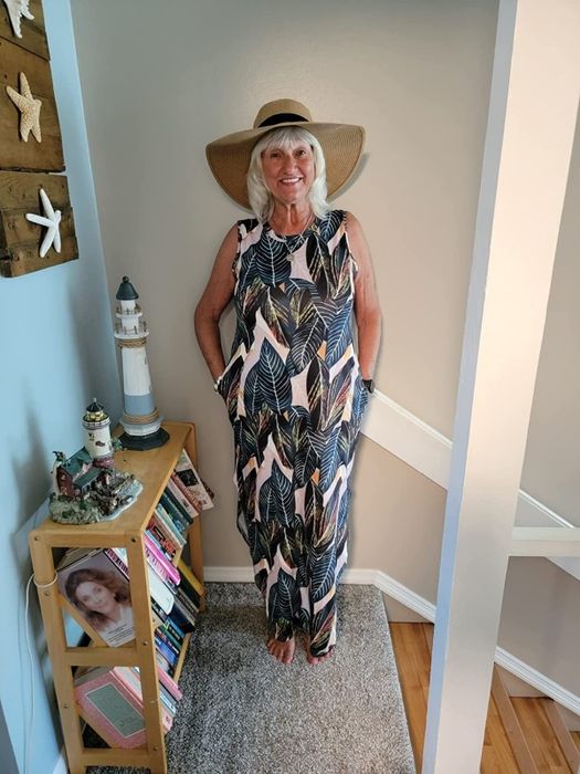 The reviewer is wearing a stunning leaf-patterned sundress.