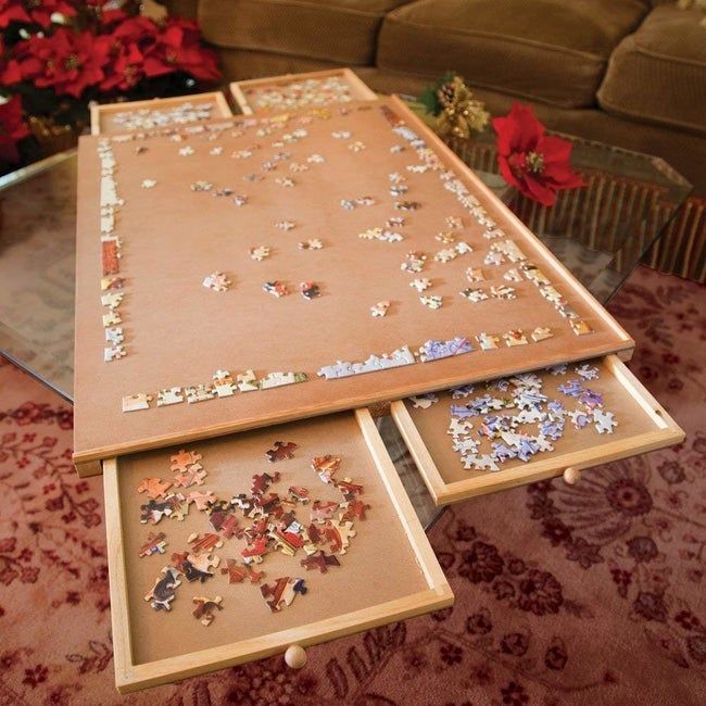 A tabletop with drawers that slide out, each holding a separate group of puzzle pieces.