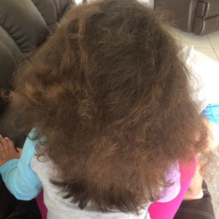 A reviewer's photo of their child with naturally wavy hair before using the hot-air brush