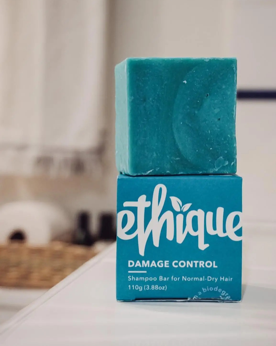 Image of a blue product box with a matching blue shampoo bar resting on a white countertop.
